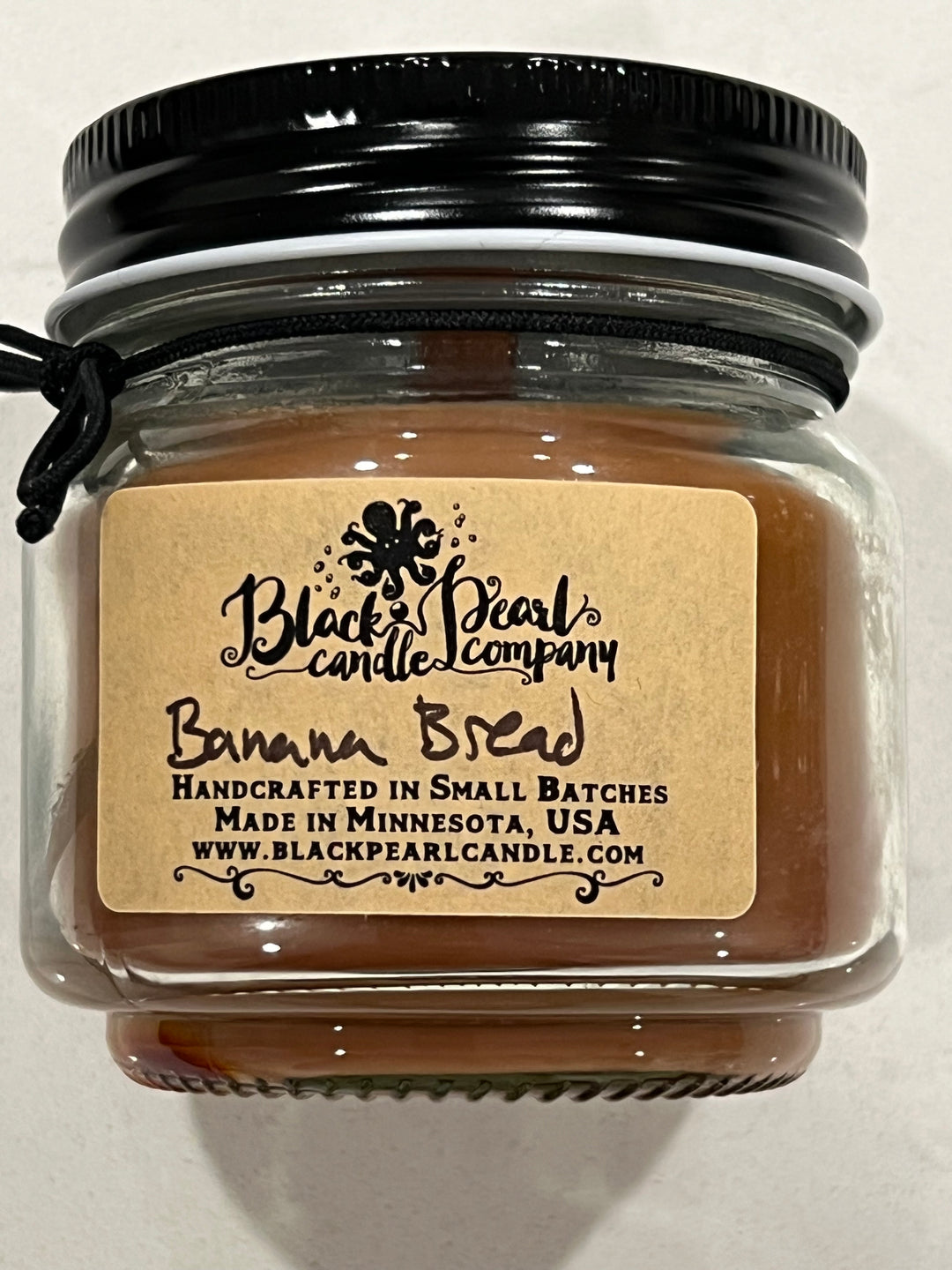 Banana Bread scented candle in 8 oz mason jar with wood wick, soy-paraffin wax, and a warm baked banana and spice fragrance