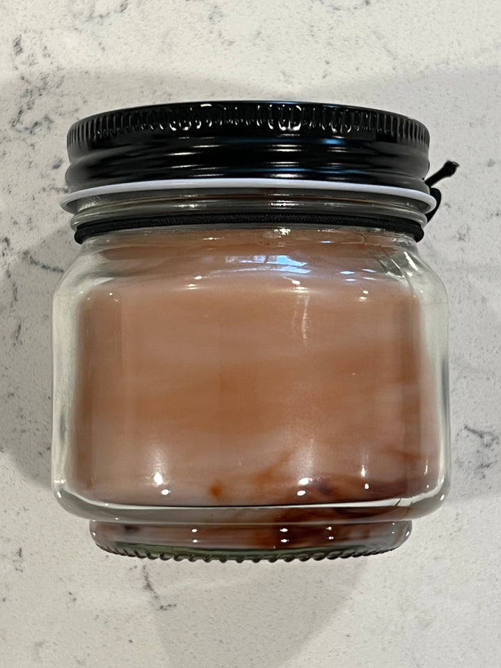 Side view of Lost Archives scented candle in 8 oz mason jar with wood wick, soy-paraffin wax, and rich sandalwood and antique library fragrance