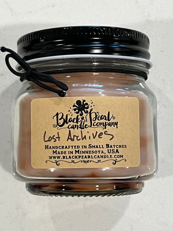 Lost Archives scented candle in 8 oz mason jar with wood wick, soy-paraffin wax, and rich sandalwood and antique library fragrance
